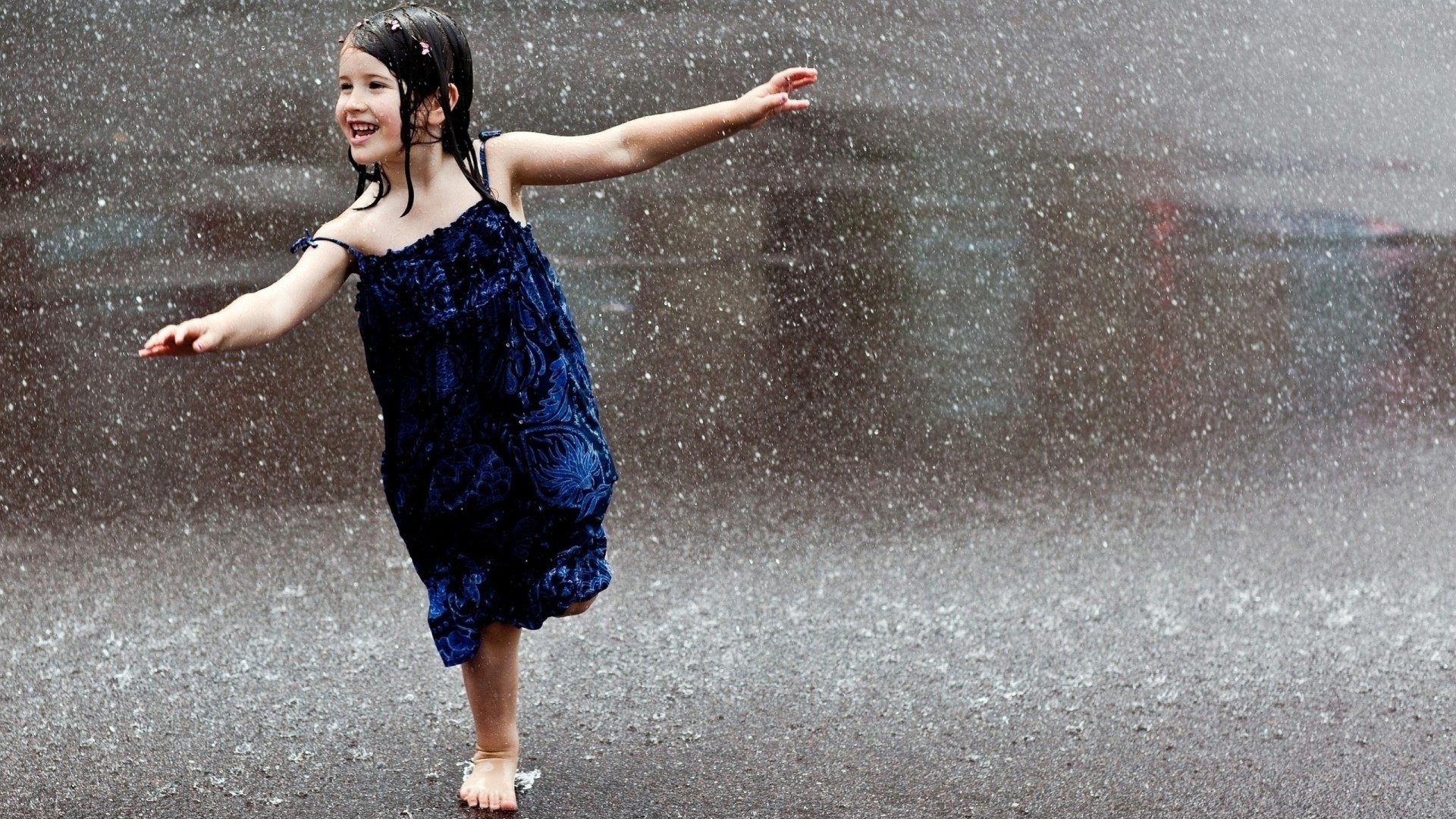 joie humide fille pluie robe bleue brunette route tombe pieds nus enfant rire