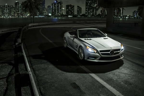 Ville de nuit et voiture Mercedes sur fond gris