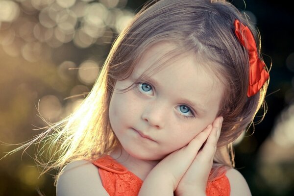 Photo of a child model with a red bow