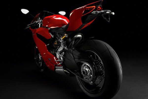 Красный спортивный мотоцикл на чёрном фоне