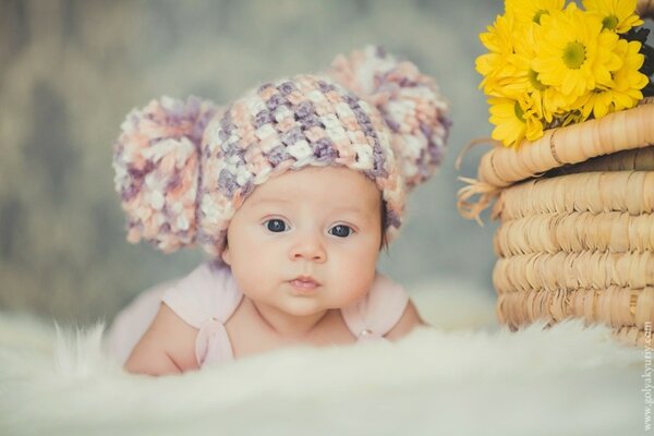 Bambino in un cappello su una coperta soffice