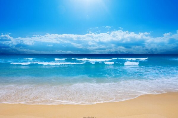 Les vagues douces de la mer sur la côte caressent le sable
