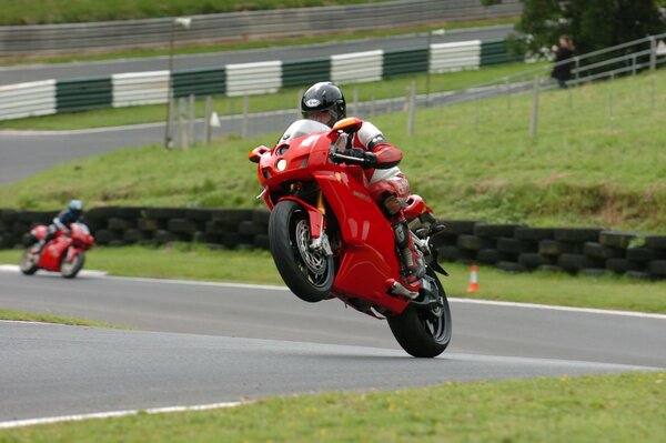 Moto roja en la pista en la rueda trasera