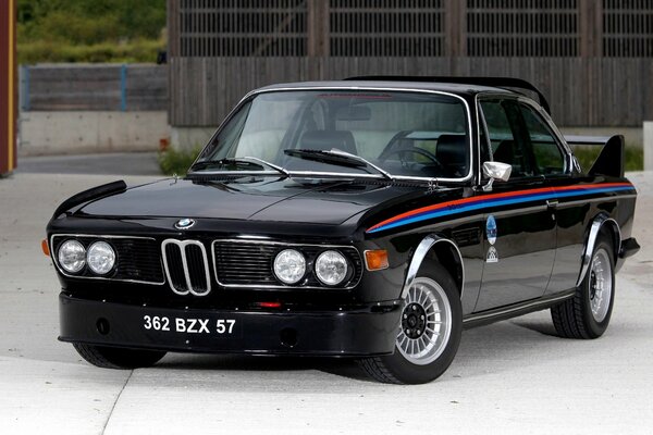 Coche negro de BMW con la raya roja y azul