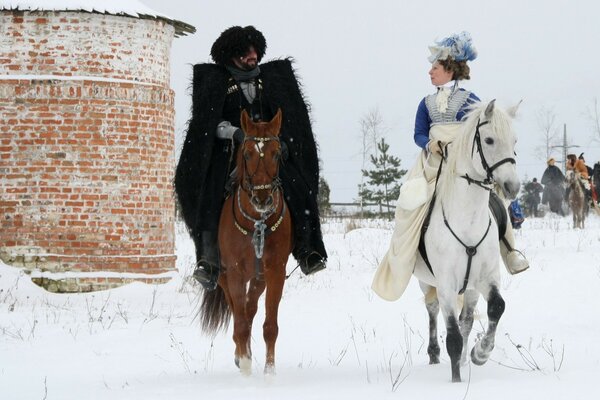 Interchina und Frau gehen im Winter auf Pferden spazieren