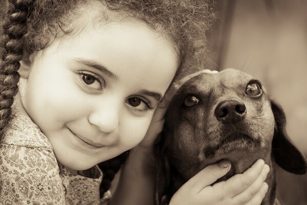 Petite fille caresse un petit chien