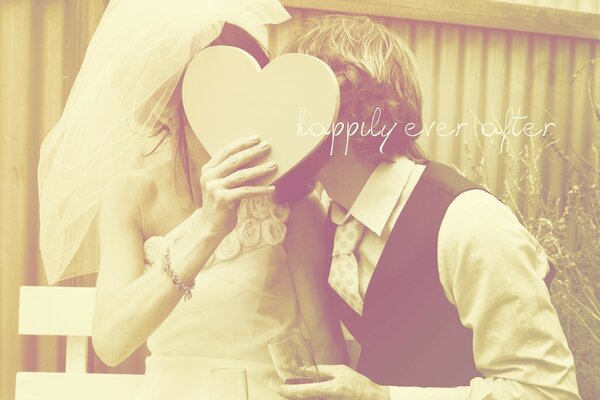 The newlyweds covered their kiss with a cardboard heart