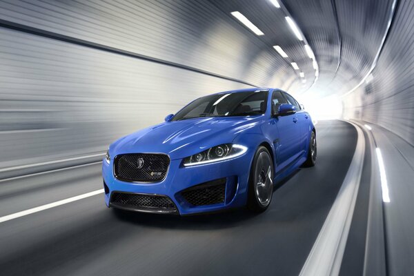 Niebieski Jaguar w tunelu z dużymi reflektorami