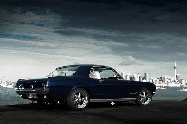 Blue Ford Mustang on the background of the city rear view