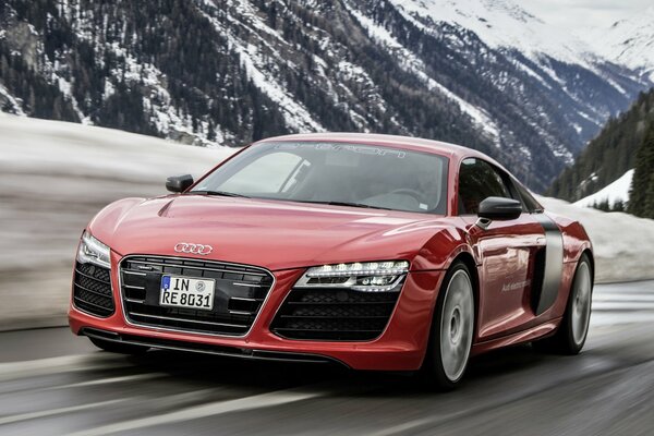 Rotes Auto audi r8 vor dem Hintergrund der schneebedeckten Berge