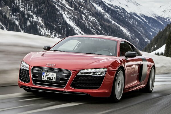 Red Audi r8 car on the background of snowy mountains