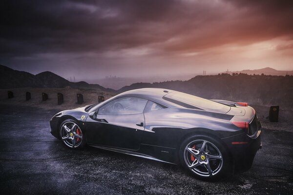 Black Ferrari in profile against the background of mountains