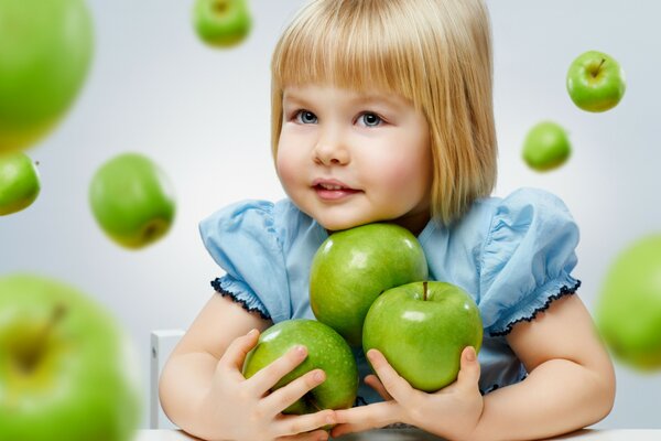 Niña modelo con manzanas verdes