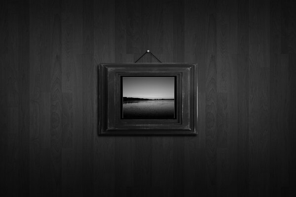 A picture in a heavy frame on a dark wall