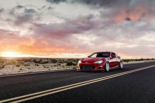 Rojo deportivo Toyota en el fondo de la puesta de sol