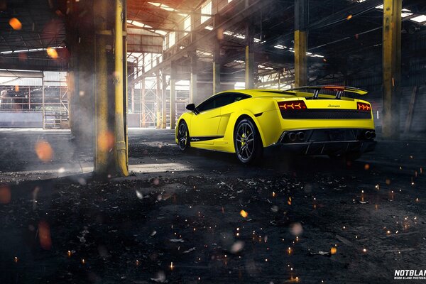 Żółta Lamborghini wyjeżdża z dużej fabryki