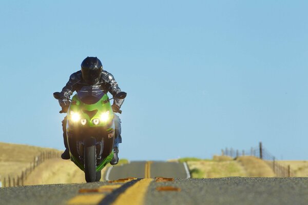 Grünes Motorrad auf gerader Straße