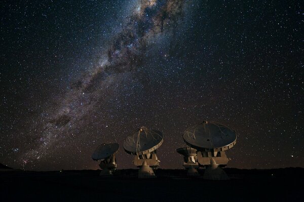 Four radio telescopes on the background of the galaxy