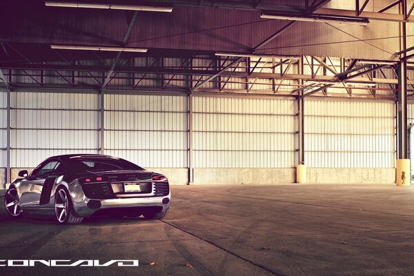 A cool Audi is standing in an empty hangar