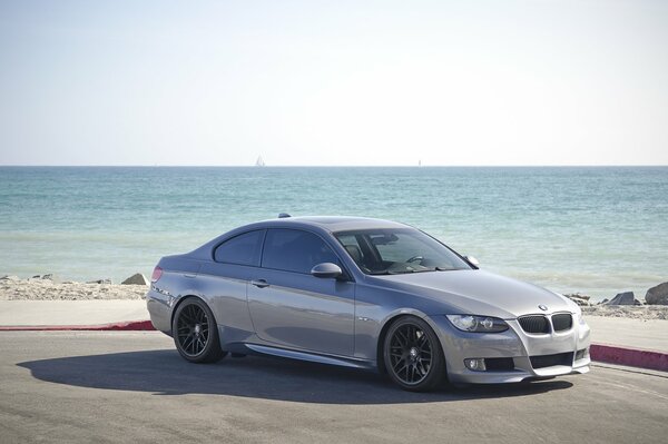 Серый купе BMW 335i тень пляж море