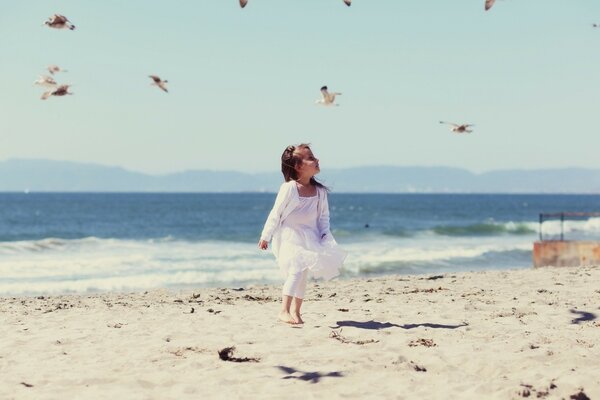 Bambina che corre sulla spiaggia