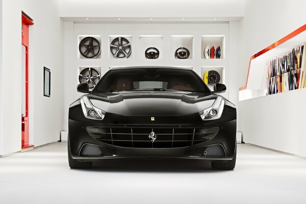 Ferrari noir dans le garage sur fond de mur avec des disques