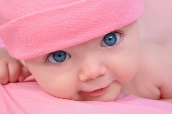 Enfant aux yeux bleus dans un chapeau rose