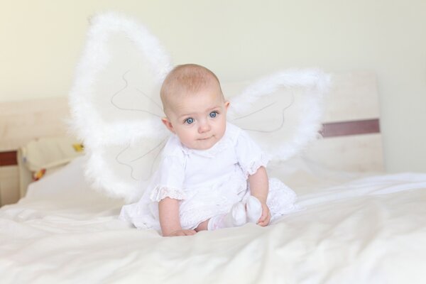 Baby angel on a white bed