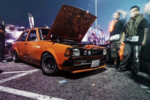 Toyota Corolla orange. Les gens en mouvement