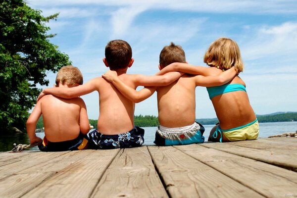 Cuatro niños sentados en el muelle