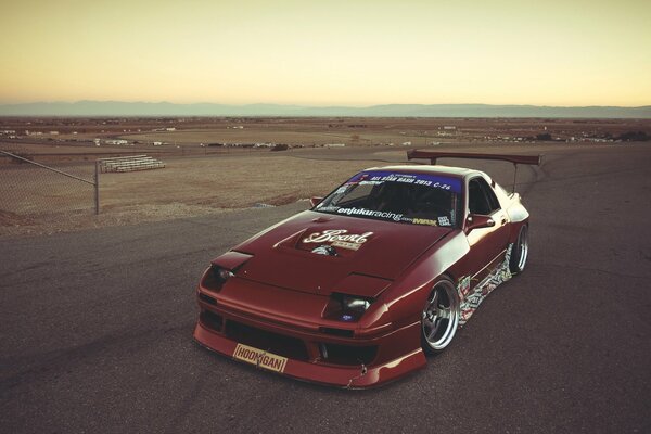 Mazda rx7 en medio de una carretera desierta