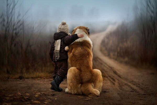 Das Kind umarmt seinen besten Freund mit dem Hund