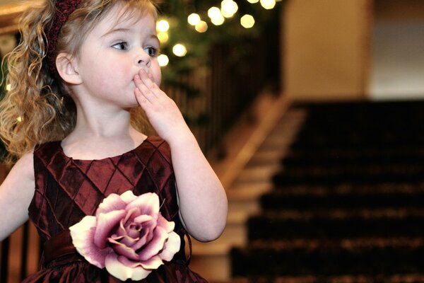 Foto eines Kindes mit einem schönen Kleid mit einer Rose