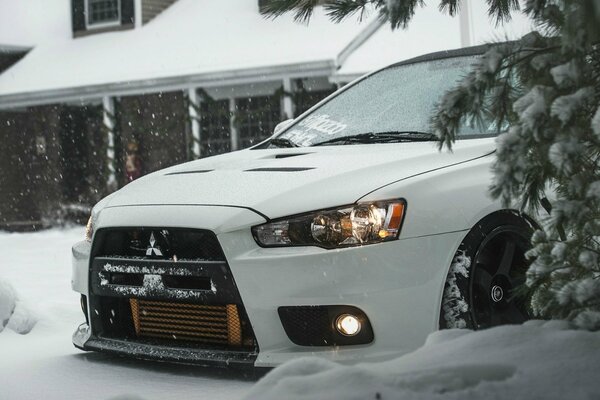 Winter photo of a car on the background of a house