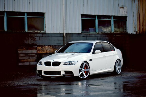 White Bmw with silver wheels after rain