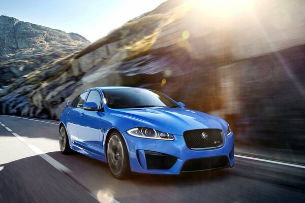 Niebieski Jaguar sedan w blasku słońca