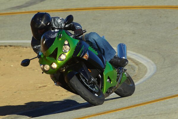 Зелёный мотоцикл в повороте на треке