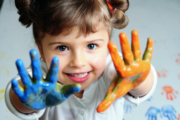The girl in the blue paint of the right palm and the orange paint of the left palm