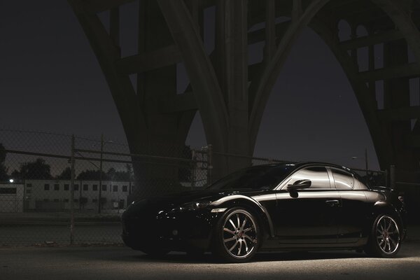 Mazda RX-8 negro bajo el puente en la noche