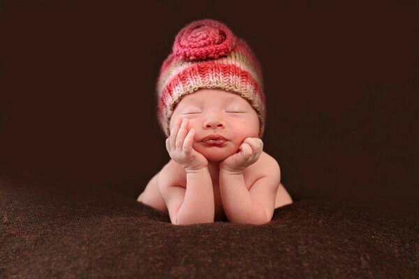 Petit bébé endormi sur fond de cachemire brun