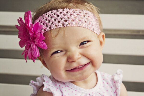 Una niña con una flor sonríe