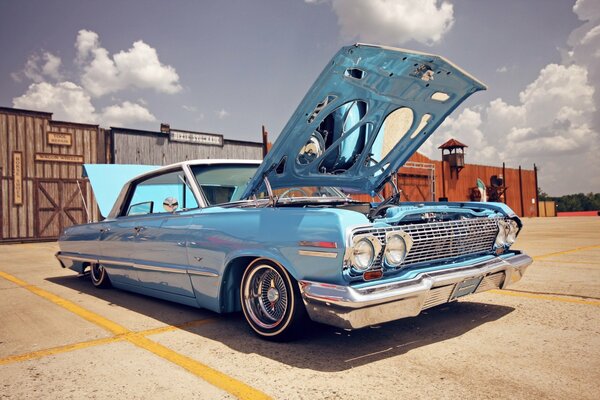 A blue Chevrolet car with an open trunk