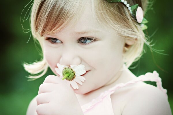 Chica alegre sostiene una flor