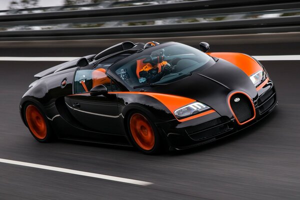 Rennwagen in Schwarz-Orange fährt auf Asphalt