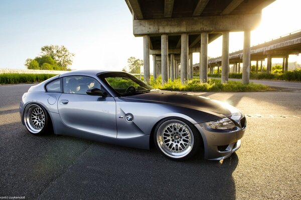 Vehículo gris marca BMW bajo puente de concreto