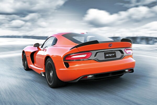 Orange Dodge Viper auf einem Hintergrund von Wolken