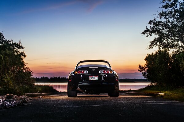 Toyota al atardecer cerca del lago