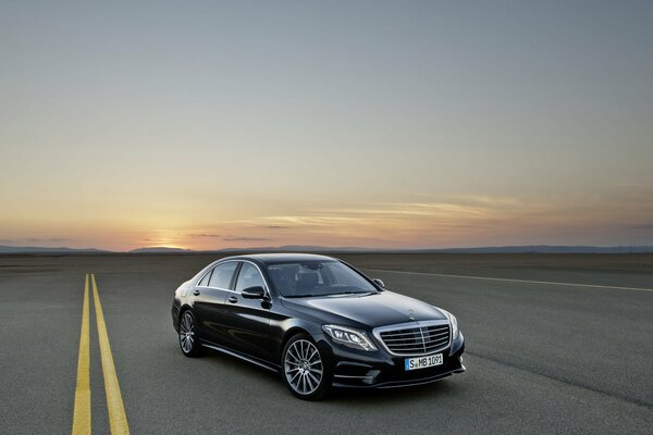 There is a beautiful, black car on the road