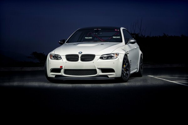 On a dark background there is a beautiful, white car