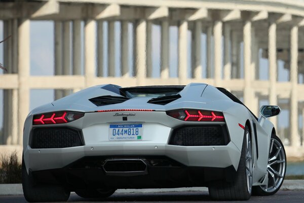 A new white Lamborghini stands in front of the building